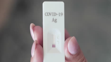 holding rapid swab test kit and waiting for result for covid-19 detection