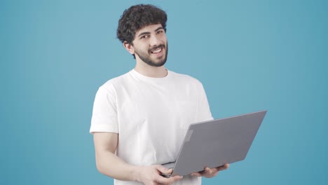 Young-man-looking-at-laptop-screen-and-making-check-mark-looking-at-camera.