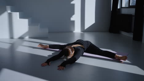 woman doing yoga stretches on mat