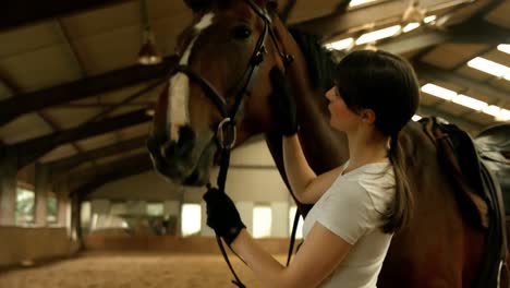 smiling brunette stroking her horse