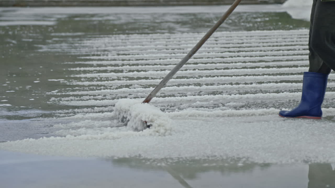 Worker harvesting salt in a salt pan