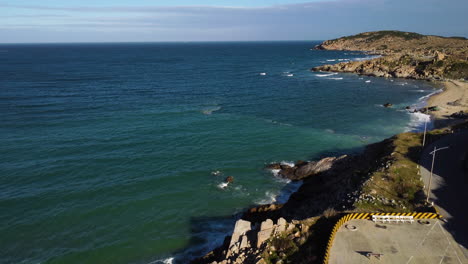 beautiful seascape, empty parking lot beside coast, garbage in sea aerial rising