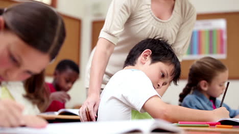 Cheerful-teacher-helping-a-pupil