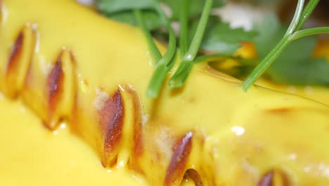 close-up of food with yellow sauce and green herbs