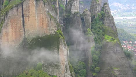 fog rises around the cliffs of meteora greece