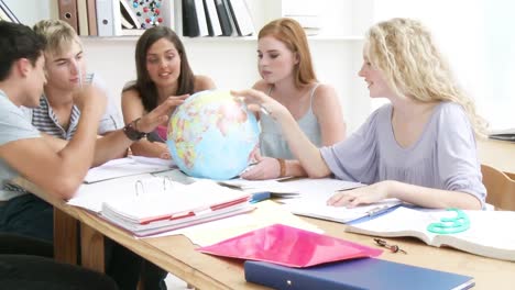 teenagers in a library working with a terrestrial globe