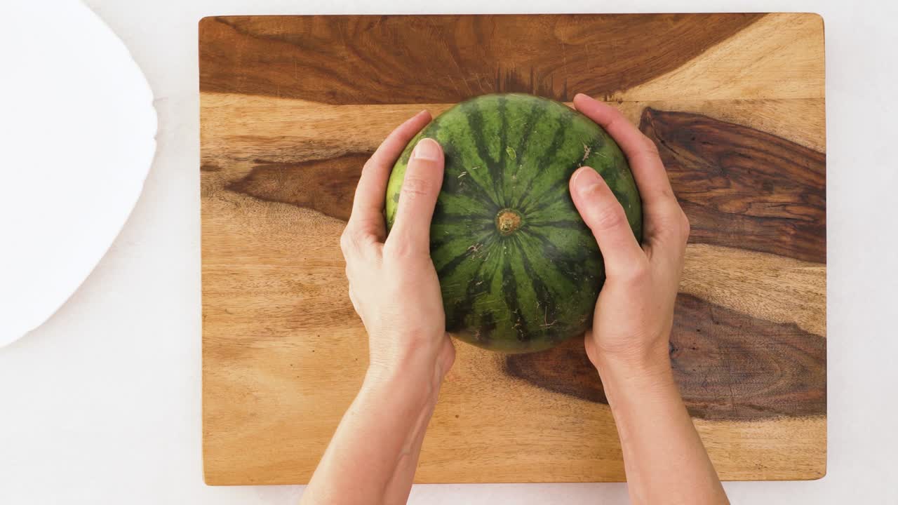 나무로 된 절단판에 신선한 유기농 수박, 위에서 가까운 시각, 여성의 손