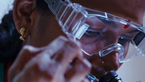close-up of a scientist working with a microscope in a lab