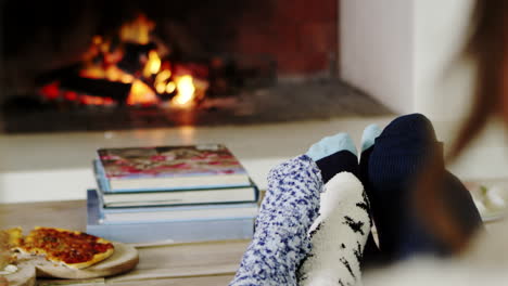 close up of family warming feet by open fire