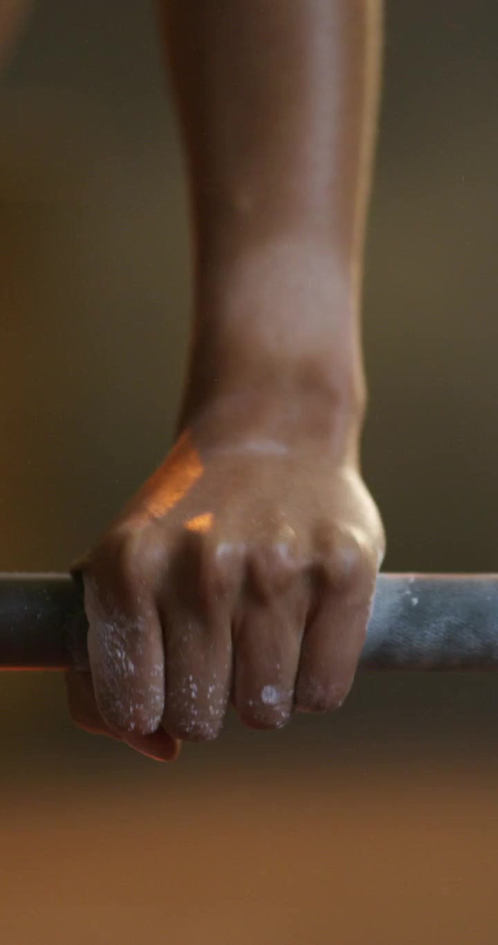 Atleta che afferra un bilanciere con le mani gessate in palestra