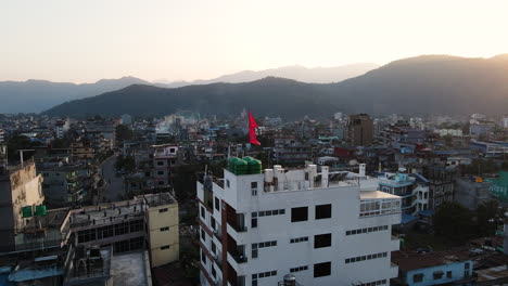 waving flag over rooftop of a building in the city of pokhara, nepal