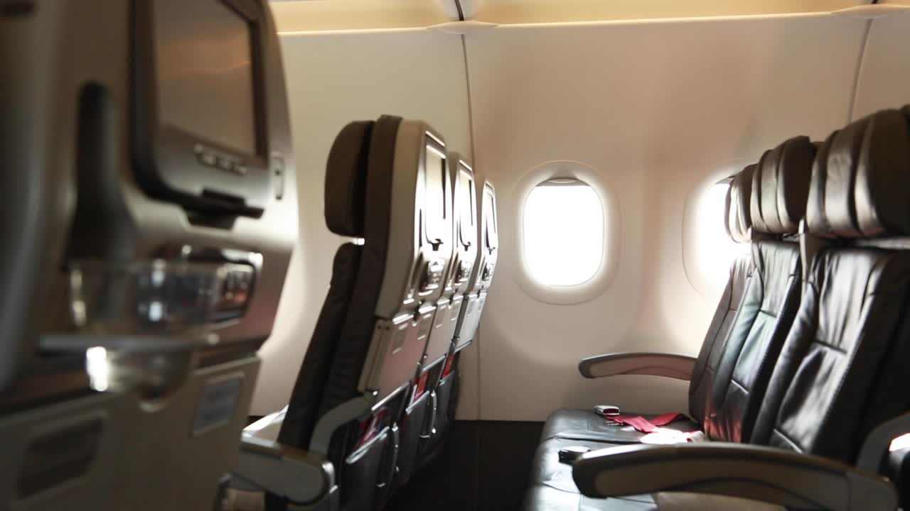 cámara de mano disparada dentro de un avión que muestra dos filas de asientos vacíos
