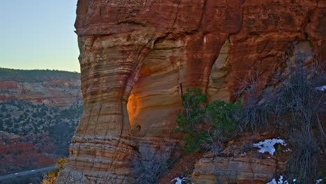 dramatic drone footage revealing a secluded natural arch glowing in the morning light near kanab, utah.