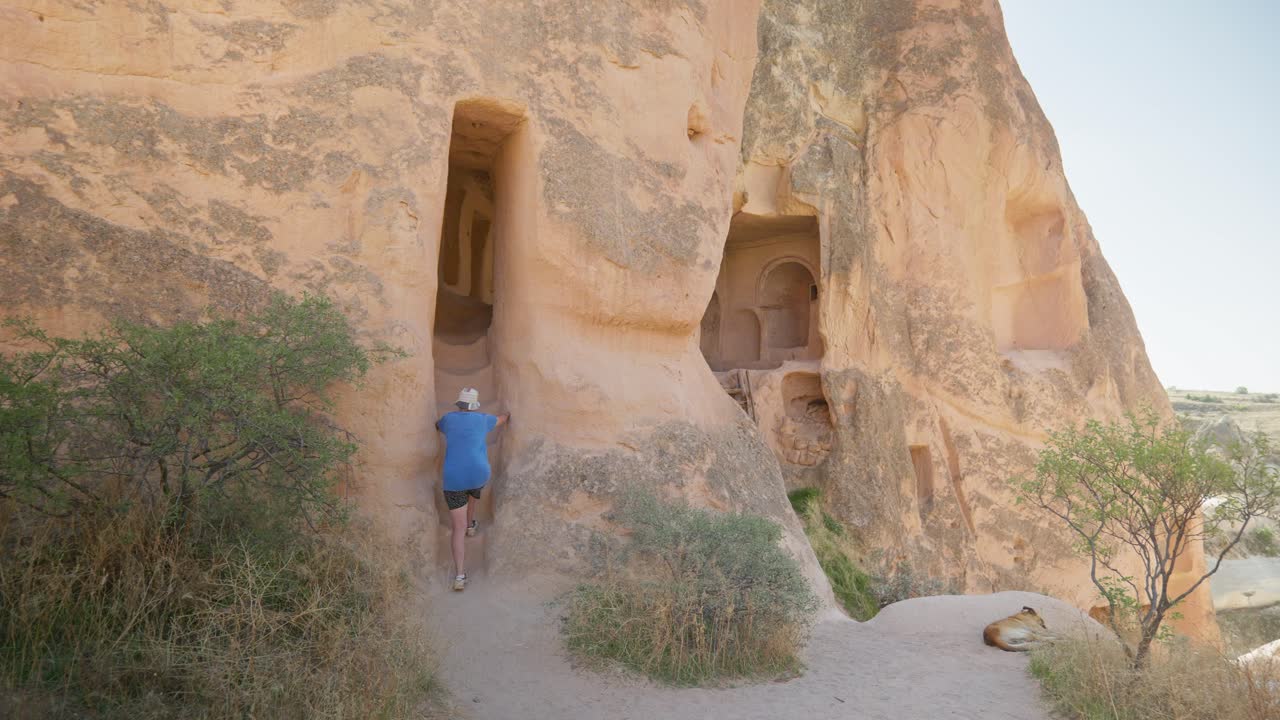 una excursionista explora las casas de las cuevas de roca el sendero del valle rojo cappadoccia