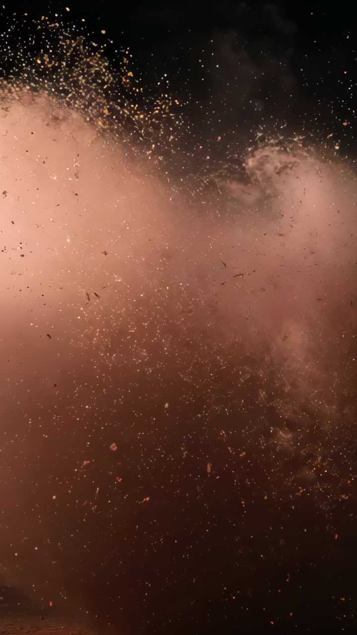 Vertical video: Powder cloud expanding in studio after sudden eruption, scattering golden sparkles