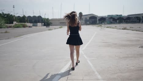 woman walking away on a concrete road