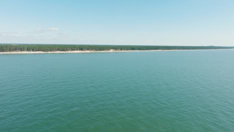 Vista-Aérea-De-La-Costa-Del-Mar-Báltico-En-Un-Día-Soleado,-Lejana-Costa-De-Arena-Blanca-Y-Bosque-De-Pinos,-Amplio-Disparo-De-Drones-Ascendentes-Avanzando