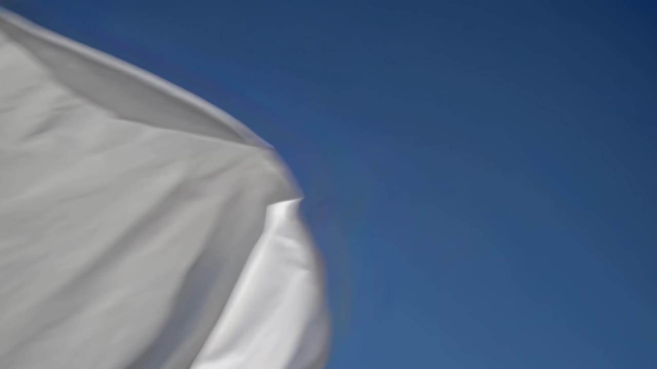 Aerial video captures smooth, flowing snow dunes against a deep blue sky, showcasing serene natural