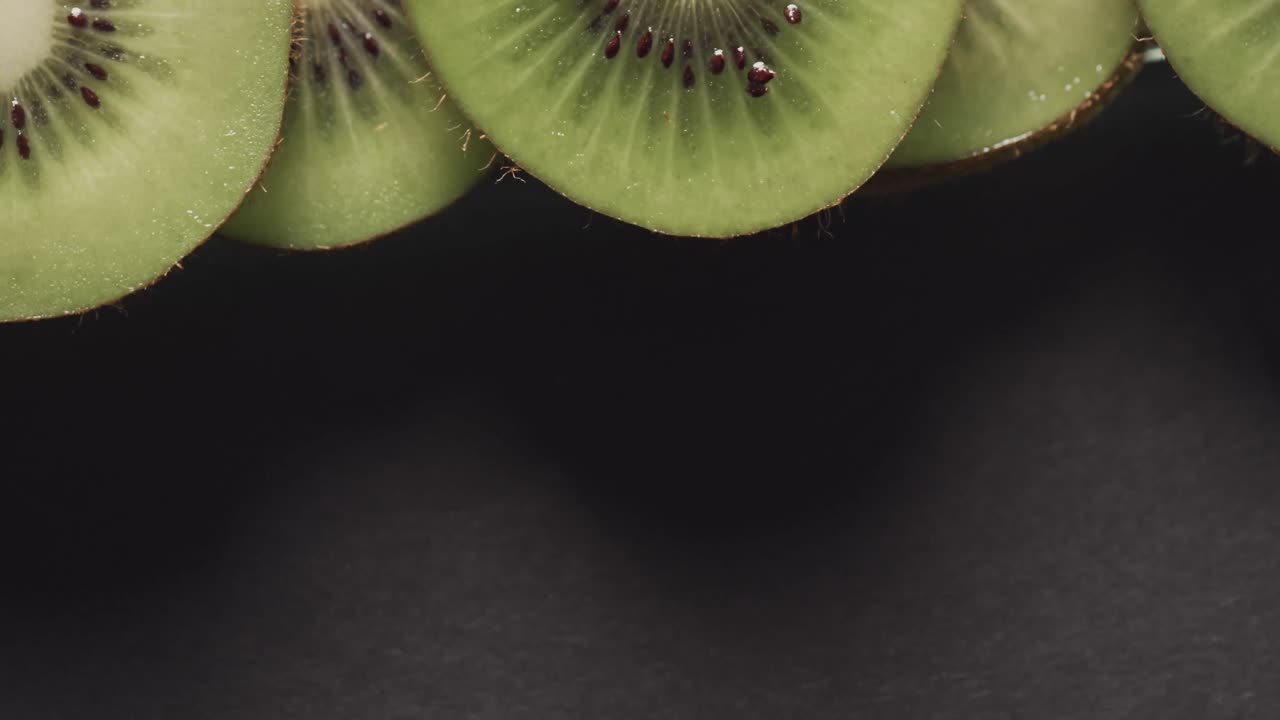 micro vídeo de close-up de fatias de kiwi com espaço de cópia em fundo preto