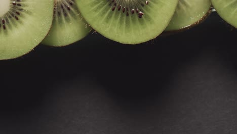 micro vídeo de primer plano de rebanadas de fruta de kiwi con espacio de copia en fondo negro