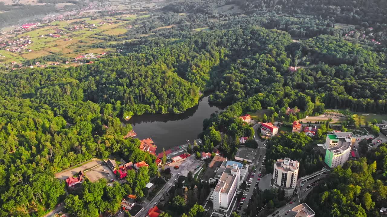 Ursu Lake, forest and houses from above in Sovata. Aerial drone shot