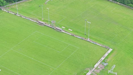 a soccer field with lush green grass and distinct white lines marks the playing area. goals stand at each end, surrounded by trees, creating a perfect spot for outdoor sports and recreation