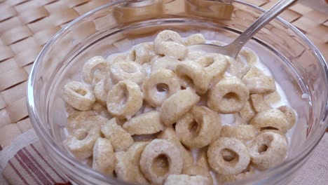 copos de avena crujientes en un tazón para un delicioso desayuno matutino con leche. cámara lenta con toma de seguimiento de rotación.