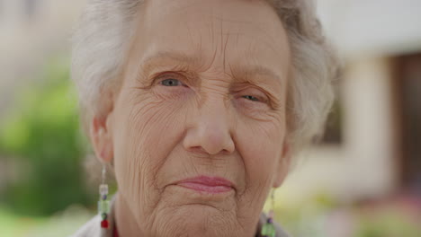 retrato en primer plano de una mujer anciana sonriendo pacíficamente mirando a la cámara una anciana mujer caucásica con arrugas disfrutando de un hermoso jardín soleado al aire libre estilo de vida de jubilación