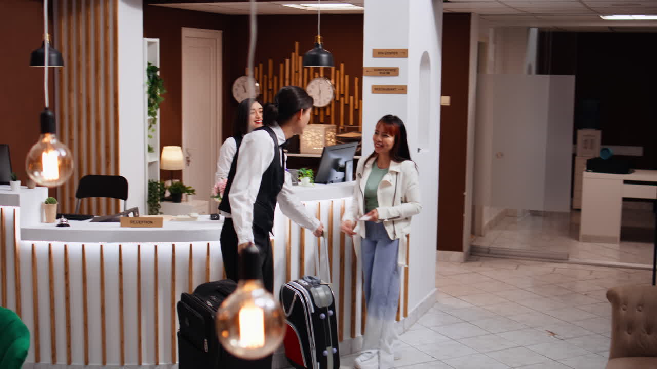 리셉션 담당자가 체크인을 마치고 고객에게 여권을 돌려줍니다.