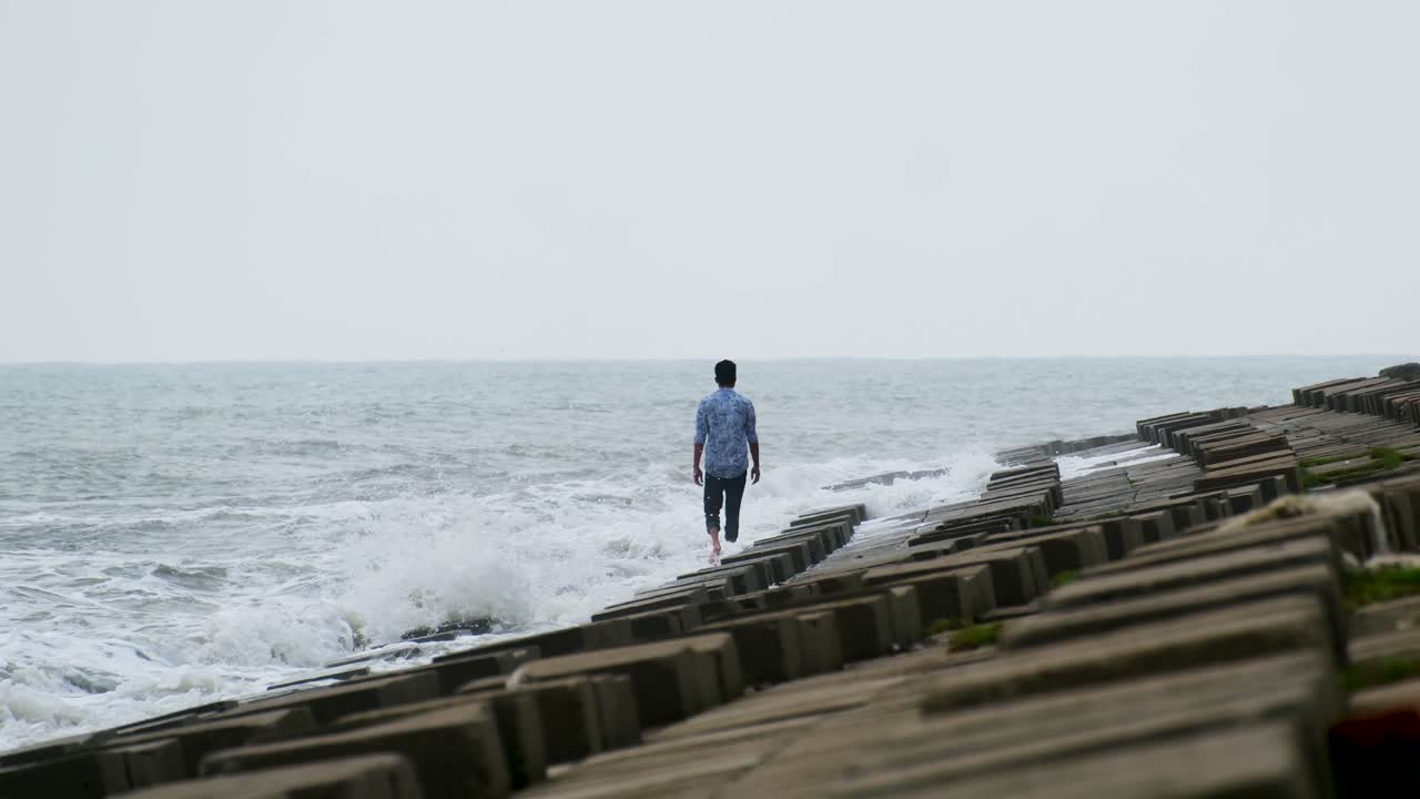 el hombre está caminando solo sobre paredes de concreto de bloque con olas ásperas