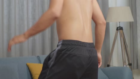 close up of asian teenager boy doing football skills during the shirtless workout at home