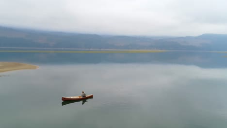 Man-rowing-boat-with-his-dog-on-a-lake-4k