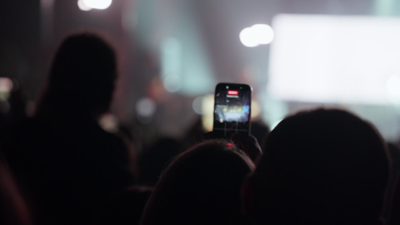 Person Recording Live Concert with Smartphone in a Crowd