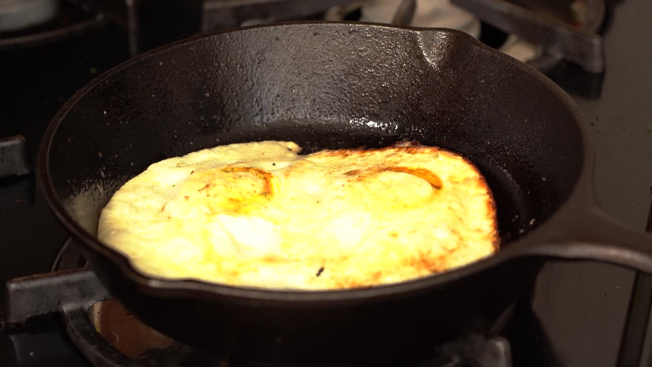 Flipping two eggs in a cast iron pan