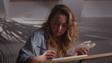 artista mujer pintando en un estudio