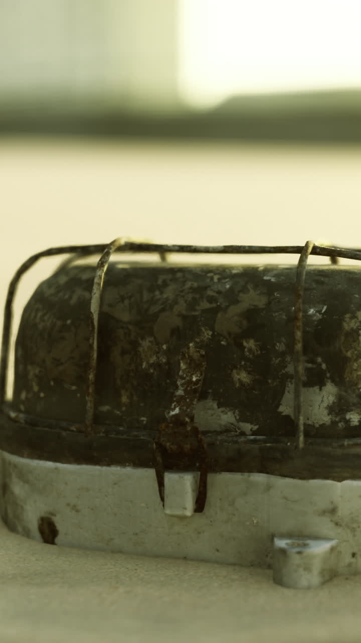 Abandoned metal object on sandy beach under warm golden sunlight
