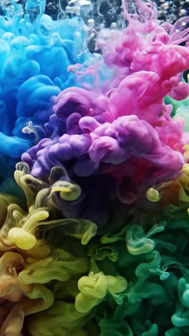 Un'affascinante dimostrazione di dinamiche fluide colorate: vortici vividi e motivi intricati emergono dalla miscelazione di coloranti vivaci su uno sfondo scuro.