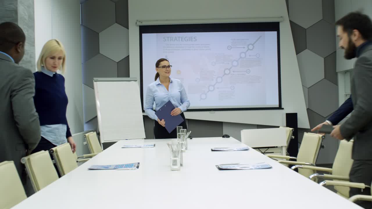 líder empresarial mujer saludando a sus colegas en la sala de reuniones