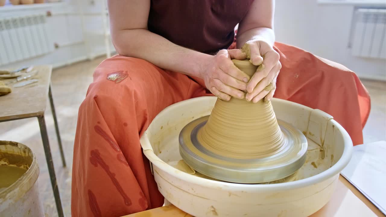 persona que da forma a la arcilla en la rueda de la cerámica