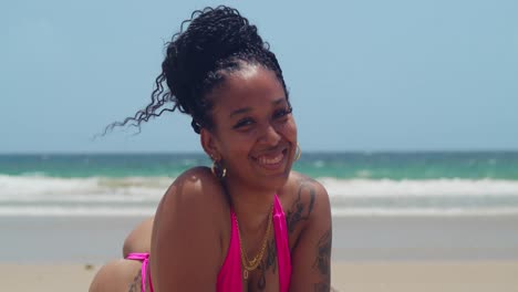 wearing her pink string bikini, a girl relaxes at trinidad's stunning las cuevas beach.