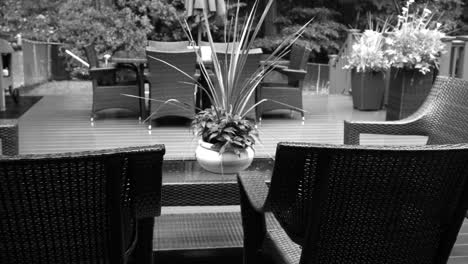 black and white video of rain lightly pattering on a suburban deck during a summer storm