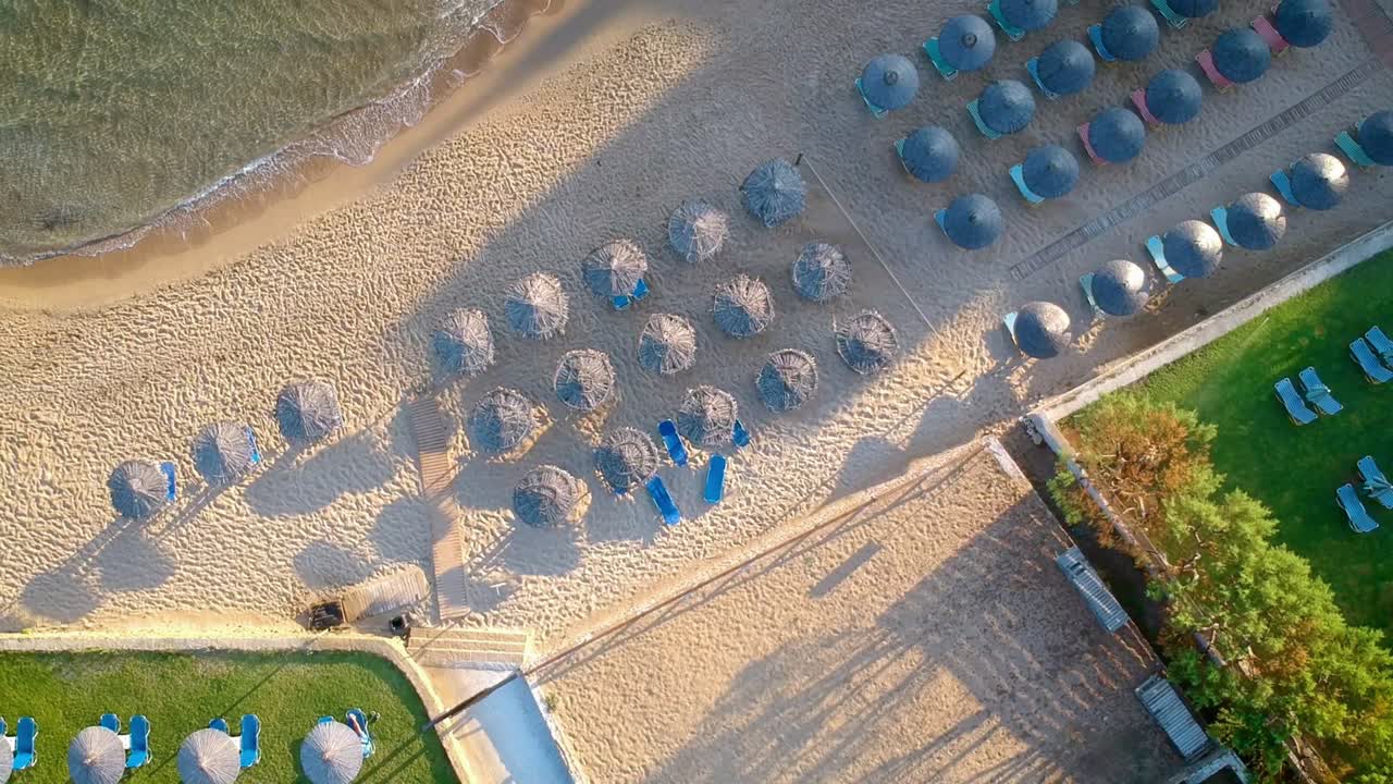 drones volando sobre las chozas dispuestas sistemáticamente en la playa turística en un día soleado
