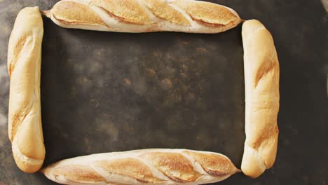 video of four baguettes forming rectangle on a black surface