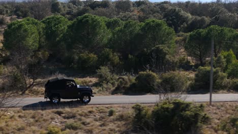 Vista-Aérea-Siguiendo-El-Jeep-Negro-Conduciendo-Por-La-Calle-En-La-Campiña-Francesa