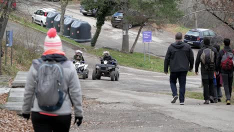 view of some people hiking down a road where a couple of quad bikes appear and stop to discuss the route to take