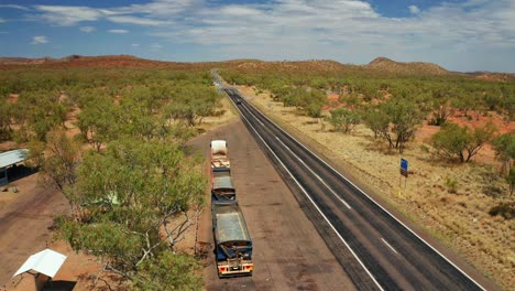 estacionamiento de camiones junto a la carretera nacional del territorio del norte con tráfico en un día soleado, interior de australia