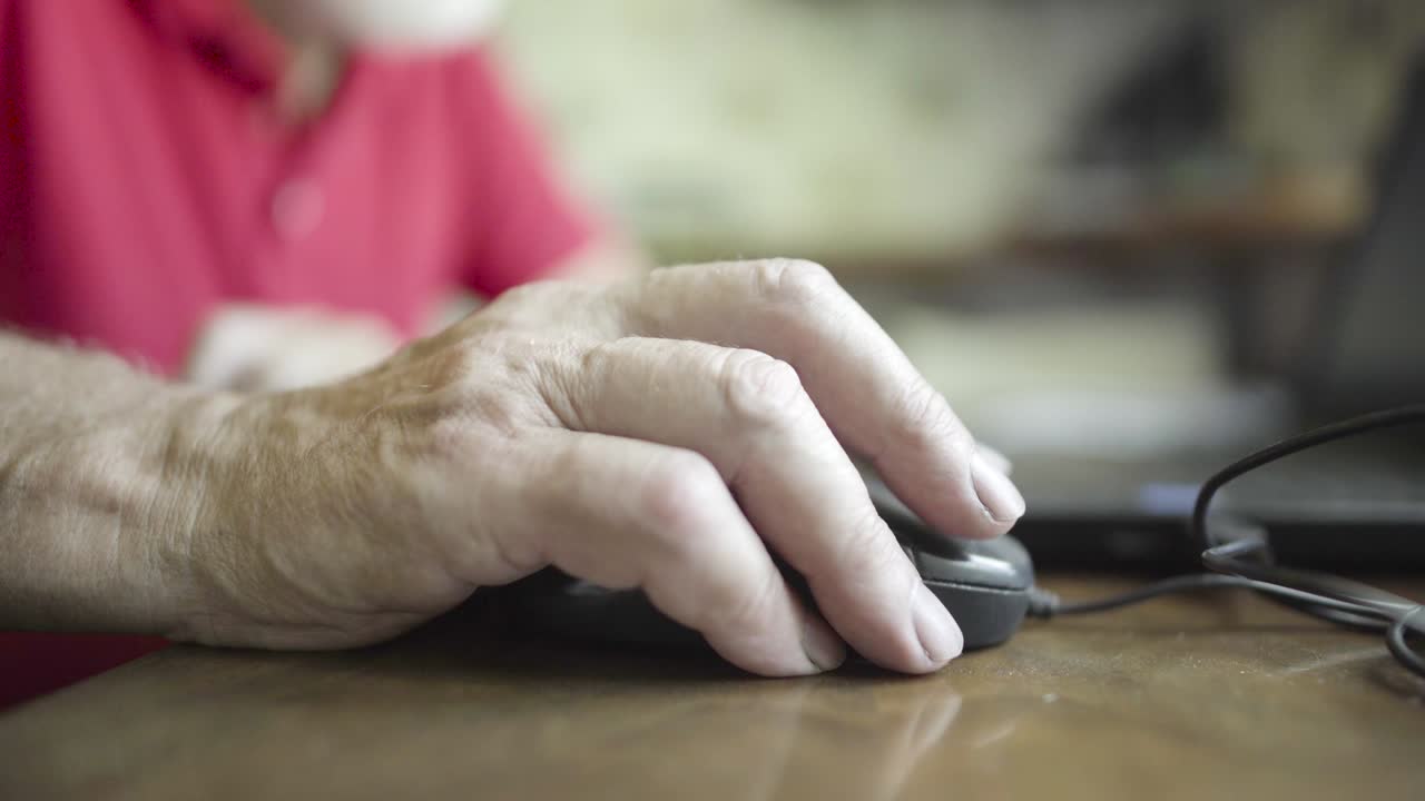 hombre mayor usando un ratón con cable