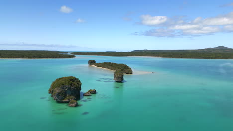 small islands in upi bay, isle of pines - aerial reveal of the pristine waters