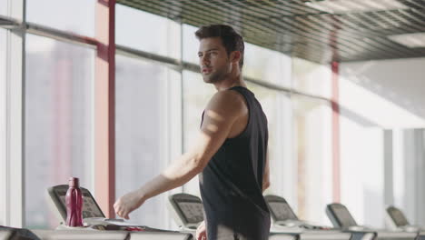 Handsome-man-looking-around-in-fitness-club.-Macho-male-walking-treadmill-in-gym