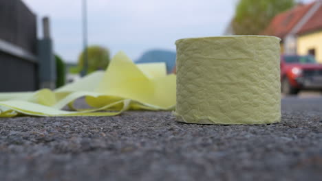 Toilet-Paper-landing-on-the-Ground-in-Slow-Motion,-Close-Up-Shot